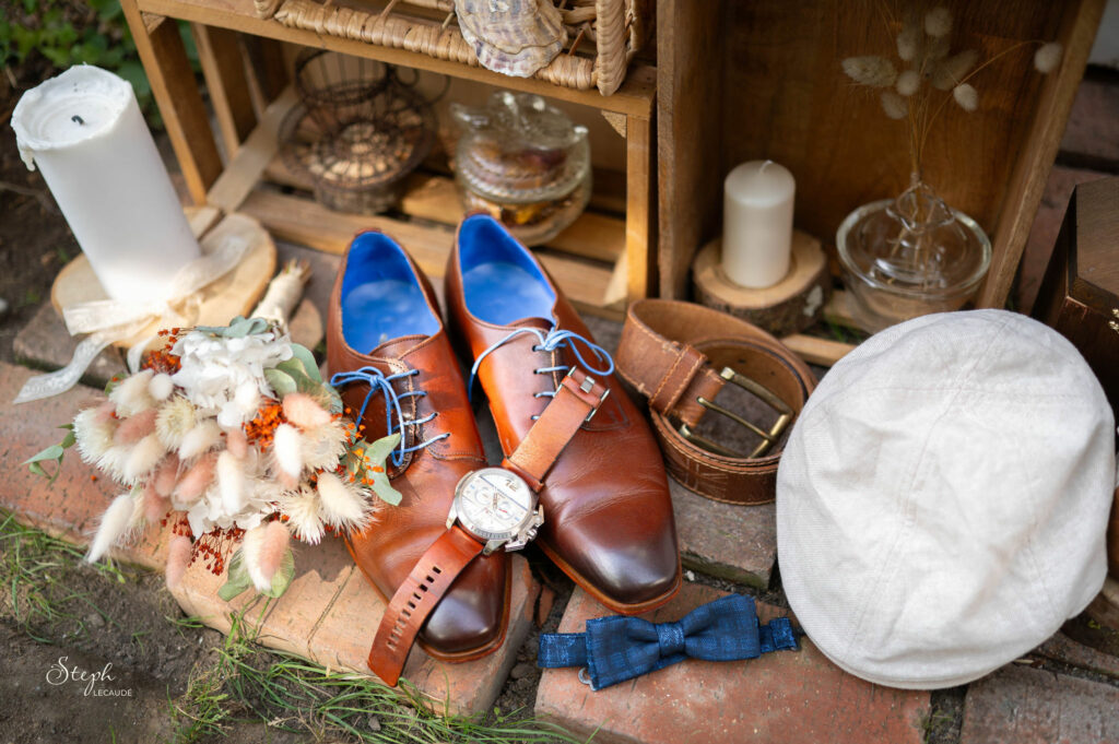 Inspirations de mariage, bouquet de fleurs séchées pour mariée, une bougie blanche, chaussures homme cirées, ceinture marron et montre, noeud papillon, béret, dispositions chic et rétro